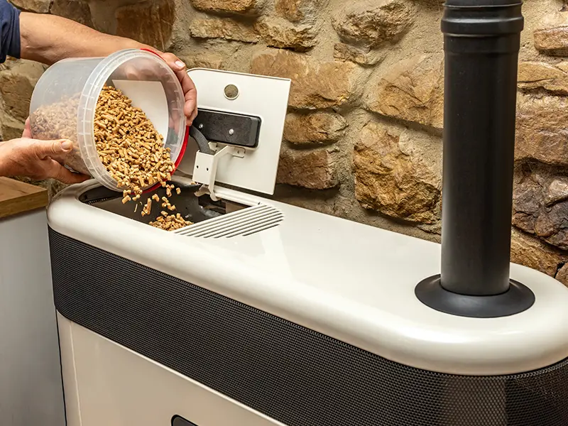 Un homme remplissant un poêl avec du pellet